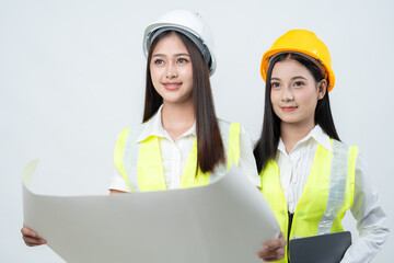 Asian female engineers review blueprints during a project meeting, emphasizing smart decision making, construction expertise, and sustainable business strategy inside a forward thinking company.