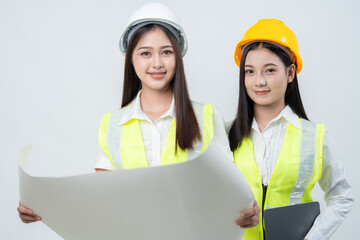 Two Asian women engineers work with blueprints and digital data, representing smart construction solutions, teamwork efficiency, and innovation supporting business growth for a company.
