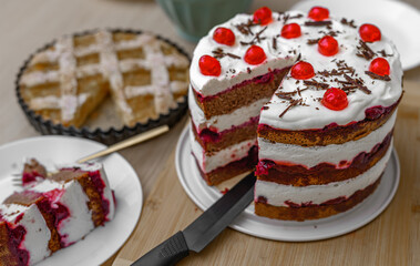 Homemade cakes, cherry chocolate cake cut into pieces on the table