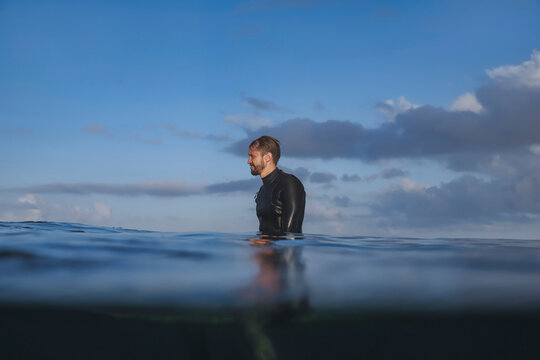 Man Surfer Sitting On Surfboard, Split Shot