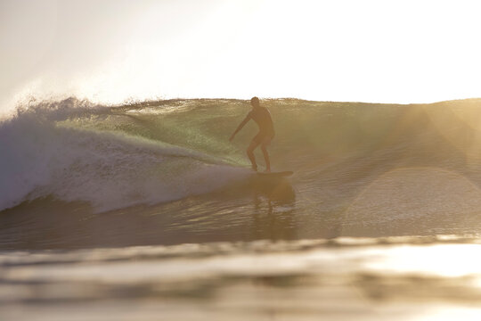Surfer Inside Barreling Wave Glowing Compressed Light