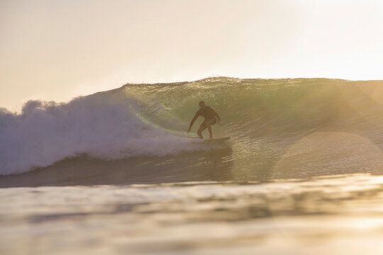 Surfer Inside Barreling Wave Glowing Compressed Light