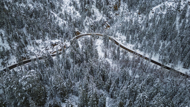 Aerial winter road winding through snowy forest near Sedona