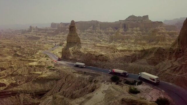 Cinematic drone shot of road and mountain passing trucks in buzi pass top Makran coastal Highway Balochistan, Pakistan