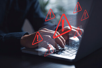 Digital Security Threat: Hands Typing on Laptop with Multiple Red Warning Signs and Code Overlays, Symbolizing Data Breach, System Error, or Cyberattack Risk