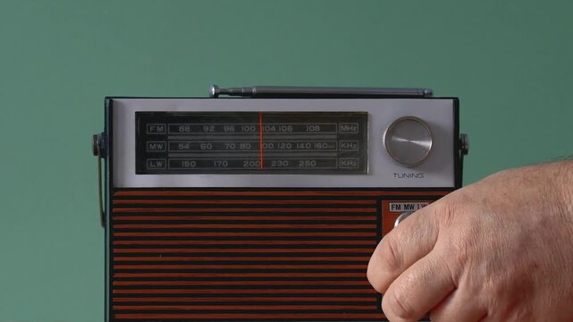 Listening to old radio while fine-tuning stations at home in simple setup an old radio from the 70s