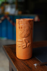 A closeup of a clay jug on a checkered surface