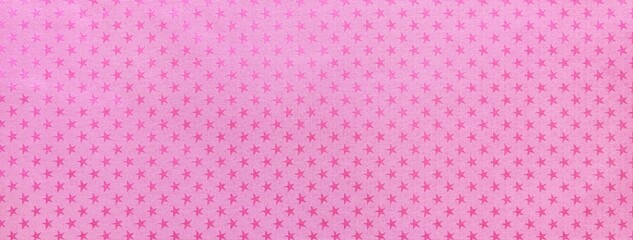 Pink paper background with lilac metal foil pattern of magenta stars for Christmas or New Year backdrop