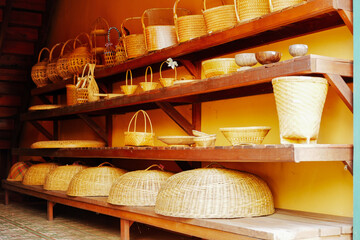  Kanchanaburi, Thailand. December 6, 2025 :A small vendor is selling braided hats, bags, baskets, and other storing products in the Ancient Market Zone in the heritage village Mallika City R.E. 124