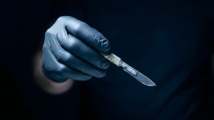 Gloved Hand Holding a Scalpel Closeup.