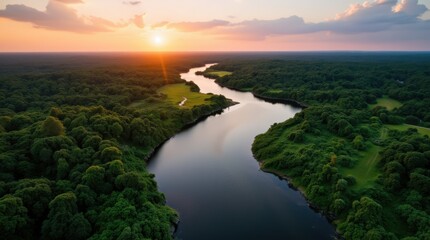 Fototapeta premium Wide river meandering through the lush green amazon rainforest at sunrise 