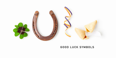 Good luck symbols isolated on white background. Composition with four leaf clover, horseshoe, party ribbon and fortune cookie