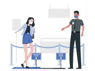 Woman and man wearing face masks standing near sanitation and wipe down signs sanitize