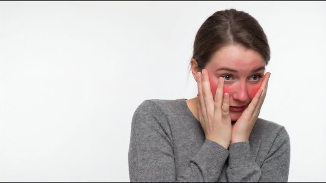 Embarrassed young woman peeking through fingers while blushing heavily
