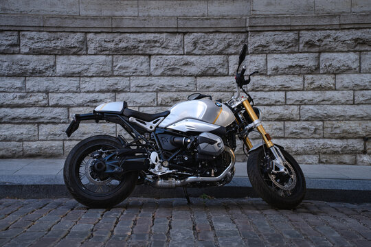 Tallinn, Harju Estonia - 26.06.2022: Custom BMW cafe racer motorcycle parked on a city street against a stone wall. Side view highlighting the boxer engine, premium design, retro aesthetics, and moder