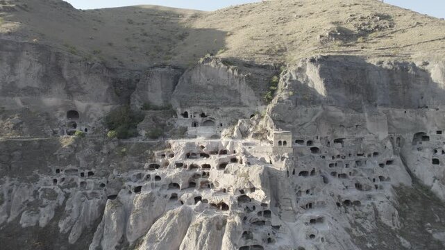 Aerial view of Vardzia, the ancient cave monastery town carved into rock in Georgia, captured at sunset