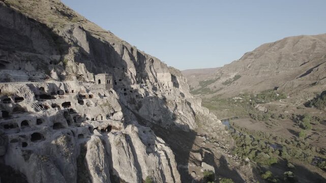 Aerial view of Vardzia, the ancient cave monastery town carved into rock in Georgia, captured at sunset