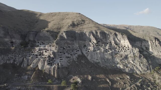 Aerial view of Vardzia, the ancient cave monastery town carved into rock in Georgia, captured at sunset