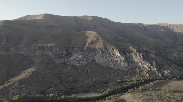 Aerial view of Vardzia, the ancient cave monastery town carved into rock in Georgia, captured at sunset