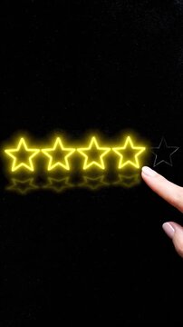 A finger illuminates a star rating of three out of five on a black background