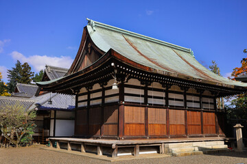 Naklejka premium Traditional Japanese Temple Building With Curved Green Roof and Wooden Lattice Details