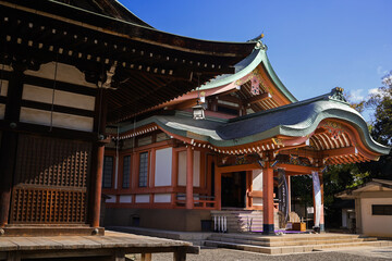 Obraz premium Traditional Japanese Temple Building With Curved Green Roof and Wooden Lattice Details