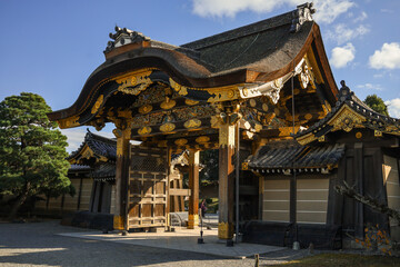Fototapeta premium Kyoto,Nijo. Historic Japanese Temple Gate With Visitors In Courtyard Under A Bright Blue Sky