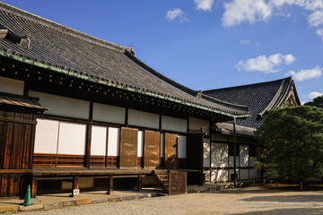 Fototapeta premium Kyoto,Nijo. Japanese Traditional Temple Complex With Sloped Roofs and Wooden Facades in Sunny Courtyard