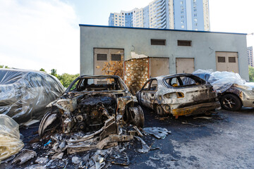 Broken and burned cars in the parking lot, accident or deliberate vandalism. Burnt car....