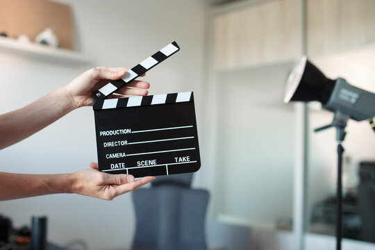 Person holding film clapperboard cueing start of production, motion video or picture, content creation