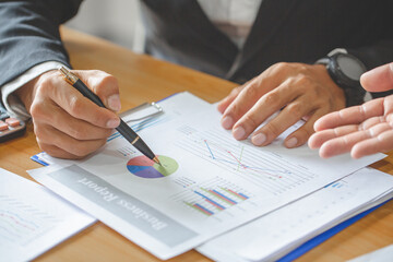 business professionals discussing financial report and charts during meeting