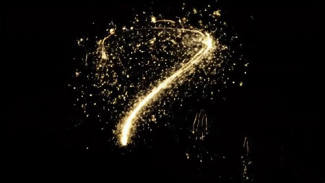 Bright golden question mark symbol drawn with glowing sparkler light
