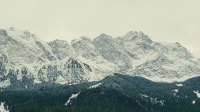 Majestic snow-covered mountains, showcasing rugged peaks and dramatic skylines next to Zugspitze, Germany&rsquo;s highest mountain. View from lake Eibsee with emerald-green waters