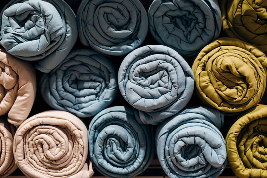 Folded weighted sensory blankets neatly stacked, soft textile texture.