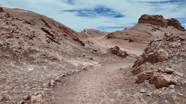 San Pedro de Atacama, Chile: POV footage of walking in desert of Valle de la Luna or Moon valley in Los Flamencos National Reserve in Atacama's desert in Chile under dramatic cloudy sky