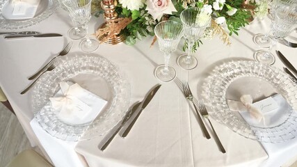 A beautifully arranged wedding table setting featuring exquisite crystal glassware and delicate floral centerpiece. Perfect for formal occasions and elegant events.