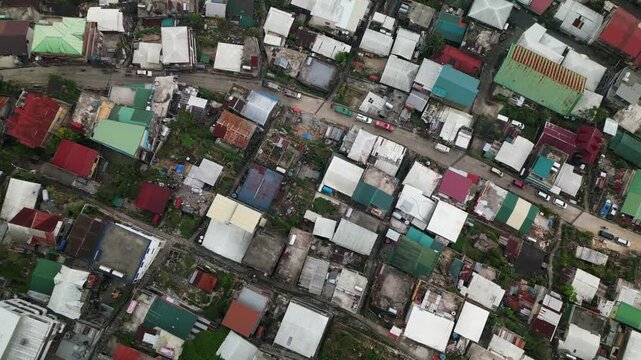 Rising aerial top-down view of dilapidated and colorful house rooftops at rural hillside barangay - Quirino Hill, Baguio, Philippines