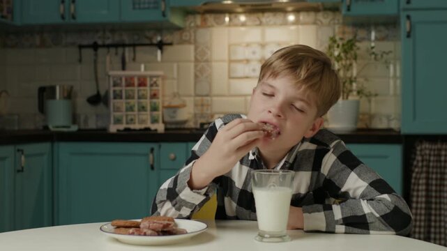 Boy Eating Cookies and Drinking Milk at Home