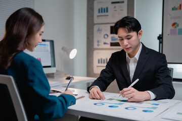 Business professionals analyzing financial data working late