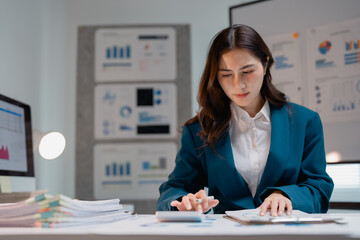 Businesswoman calculating financial data with calculator in office