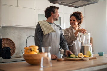 Couple In Modern Kitchen Preparing Smoothies Together During Morning At Home
