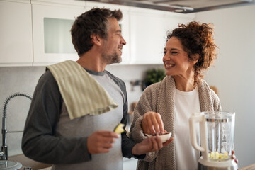 Happy Couple Cooking in a Modern Kitchen, Sharing Apples and Smoothie Preparation