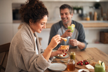 Couple Enjoying Toast With Honey at Kitchen Table During Morning Breakfast Moment
