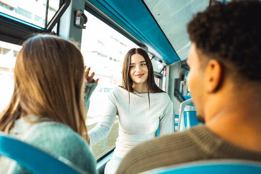 Young friends talking on public transport bus - Powered by Adobe