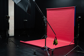 Photo studio interior with black cyclorama and red background.