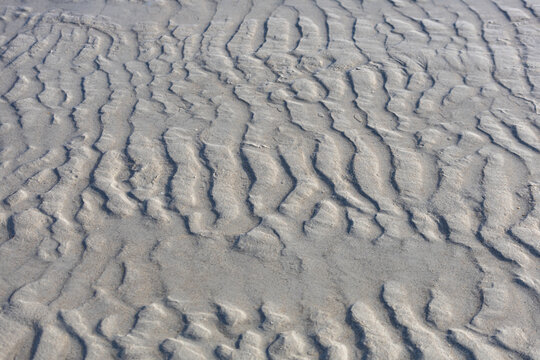 patterns on the sand from the sea waves as a background.