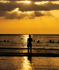 Fototapeta premium A woman stands on the beach in the water