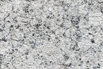 A detailed close-up of a light gray granite surface speckled with black mineral flecks