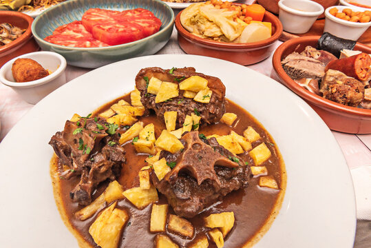 Oxtail stew accompanied by saut&eacute;ed mushrooms and pearl onions, all cooked together in the same thick, aromatic sauce