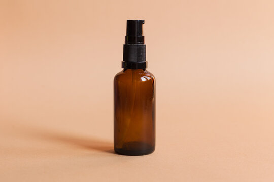 Different serum cosmetic bottles, white and dark brown dropper bottle container and packaging skincare product. studio pastel light background.